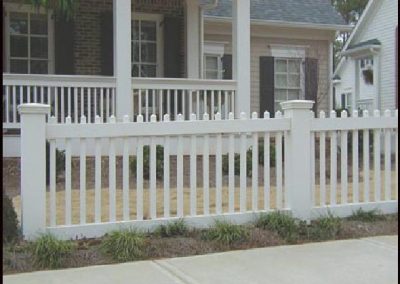 The view of medium-height whitewashed fencing around a house