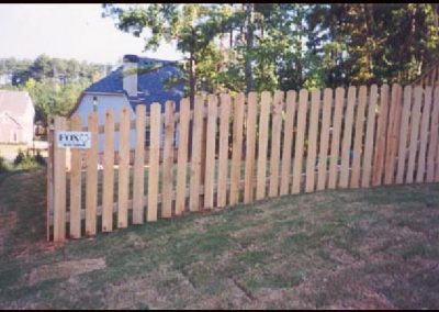 The view of straight wooden fencing with gaps