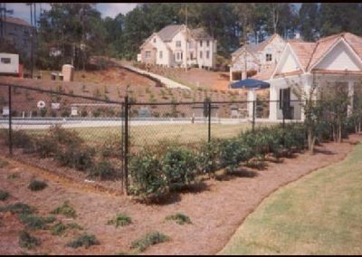 High black metal mesh fencing around the lawn of a home