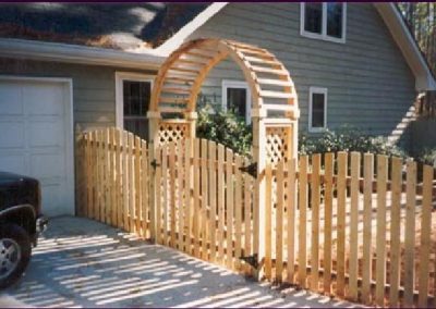 Natural wood fence with a round alter attached to the entry gate