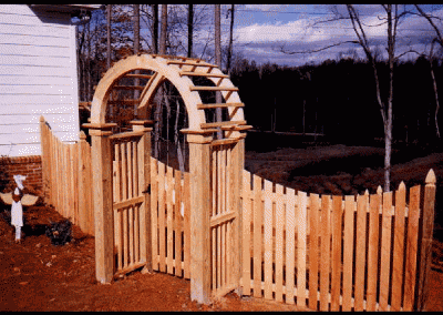 Natural wood fence with a round alter attached to the entry gate