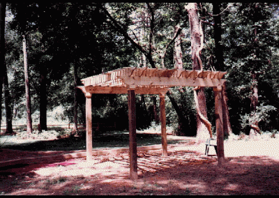 A wooden shade in the middle of a garden