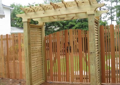 Brown and yellow wooden fencing with square alter for entry