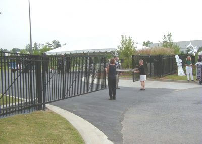 Long stretched metal fencing and entry gate along the road