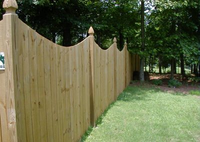 A wooden fencing with smooth wavey cuts