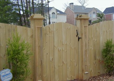 A solid natural wooden fencing along with entry gate