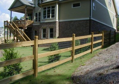 Low height wide gap wooden fencing around a farmhouse